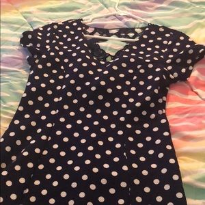 A navy polka dot dress with designs on the back.